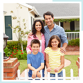 happy family of four standing outside of a house